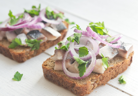 Two open sandwiches with herring, red onion and parsleyの写真素材