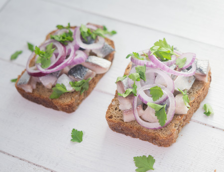 Two open sandwiches with herring, red onion and parsleyの写真素材