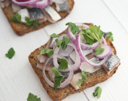 Open sandwich with herring, red onion and parsleyの写真素材