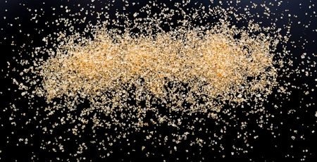 Brown cane sugar on a blackの写真素材