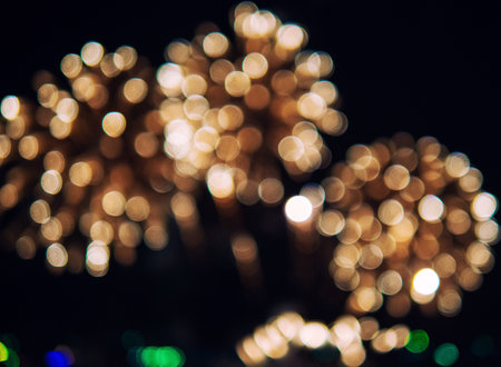The image is a blurry shot of fireworks in the sky. The fireworks are scattered throughout the...