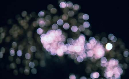 The image is a blurry shot of fireworks in the sky. The fireworks are scattered throughout the...