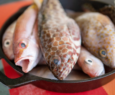 Fresh fish in cast iron skillet on a table