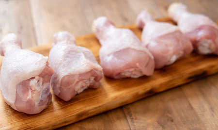 Chicken legs on wooden boardの写真素材