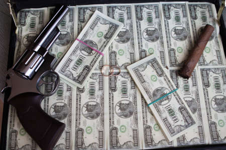 Wedding rings,gun, cigar and money in a caseの写真素材