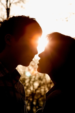 Profiles of romantic couple looking at each other on sunset back lightの写真素材