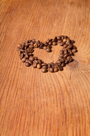 coffee beans in the form of heart on a wooden tableの写真素材