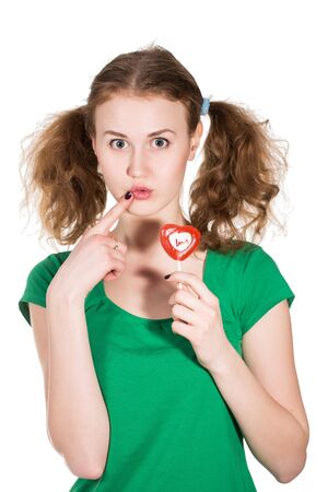 closeup shot of girl with red heart lollipop isolated on whiteの写真素材