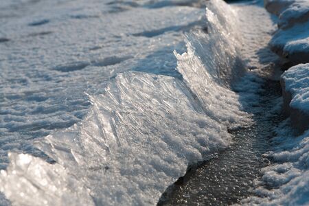 Close-up of cracked ice texture on river in spring timeの写真素材