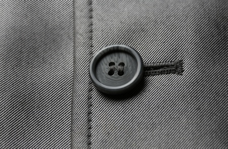 Close-up of a black button on gray material の写真素材