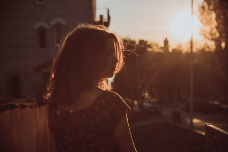 Beautiful young brunette girl sitting outdoors near the riverの写真素材