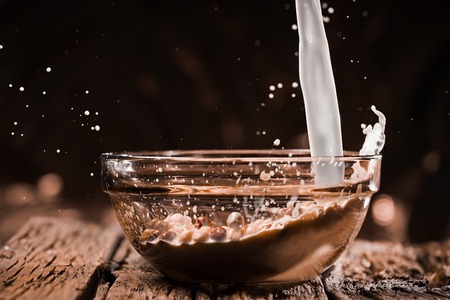 Milk pouring into bowl with chocolate balls.の写真素材