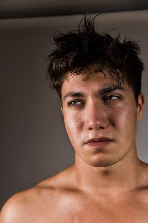 Crying man with tears in eye closeupの写真素材