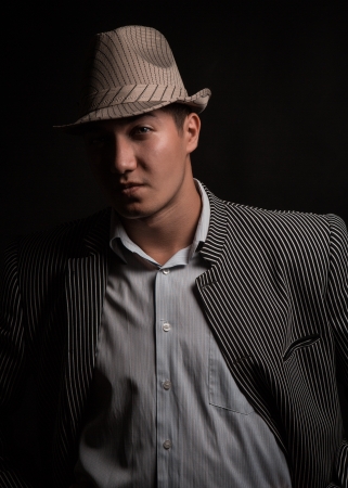 a man in a grey hat on black backgroundの写真素材