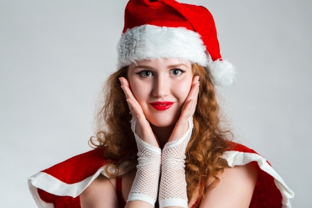 Pretty Santa girl closeup portrait, holding present gift box isolated on white backgroundの写真素材