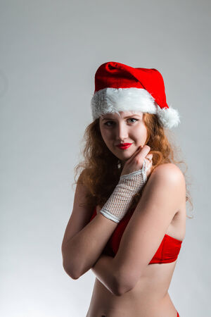 Pretty Santa girl closeup portrait, holding present gift box isolated on white の写真素材