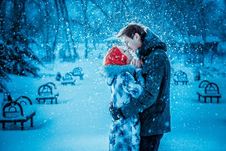 Happy Young Couple in Winter Park having fun.Family Outdoors. love kissの写真素材