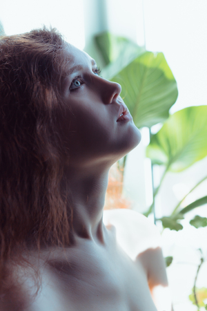 Beautiful brunette lady posing in bleached lightの写真素材