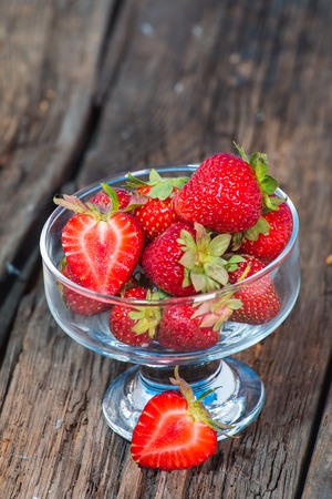 isolated strawberry isolated on rustic wooden backgroundの写真素材