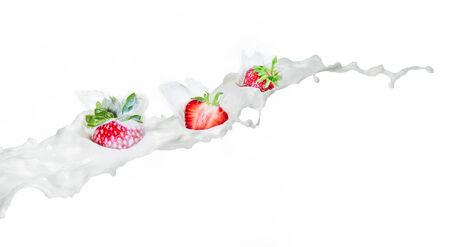 Strawberry falling into splashing milk. Isolated on white.の写真素材