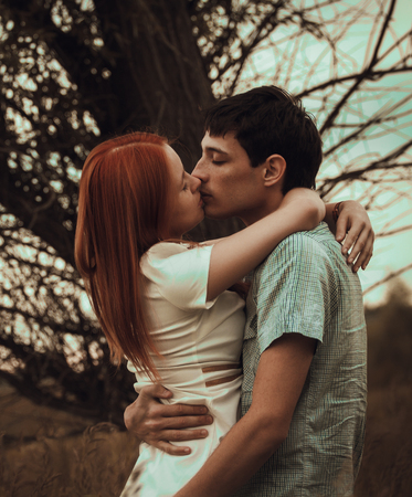 Young couple kissing on autumn fieldの写真素材