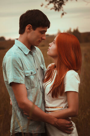 Young couple kissing on autumn fieldの写真素材