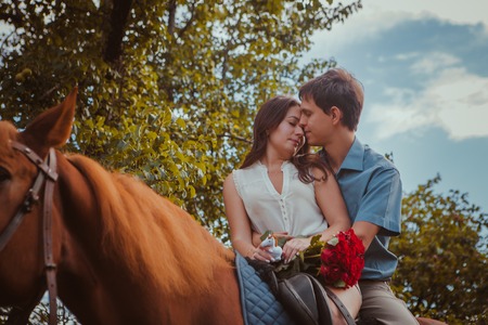 Young beautiful couple  with a horse.  Filtered. Selective focus.の写真素材