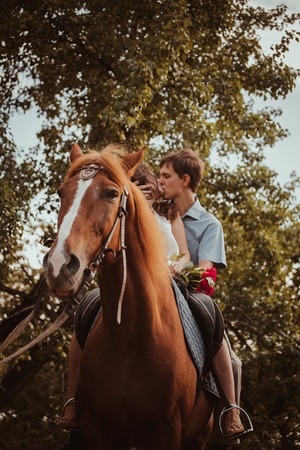 Young beautiful couple  with a horse.  Filtered. Selective focus.の写真素材