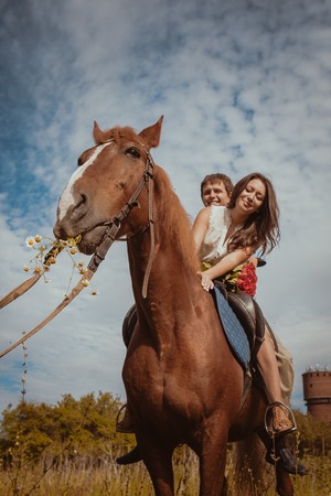 Young beautiful couple  with a horse.  Filtered. Selective focus.の写真素材