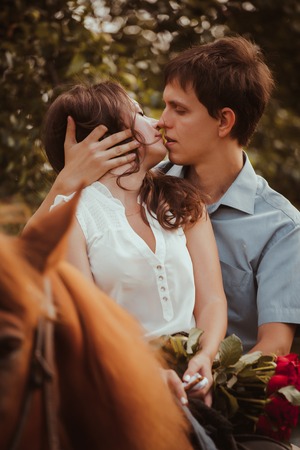 Young beautiful couple  with a horse.  Filtered. Selective focus.の写真素材