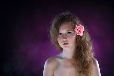 Studio portrait of young beautiful woman with roses in the smokeの写真素材