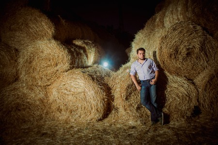 Handsome caucasian young man in the hay barnの写真素材