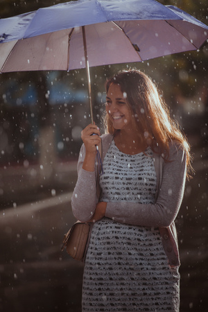 Young fashion woman with umbrella. Filtered image with blurry rainの写真素材