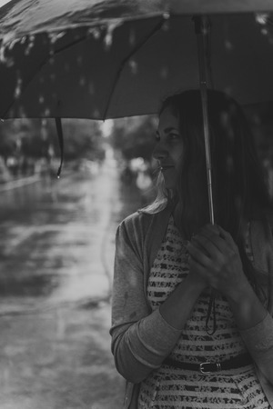 Young fashion woman with umbrella in autumn foggy morningの写真素材