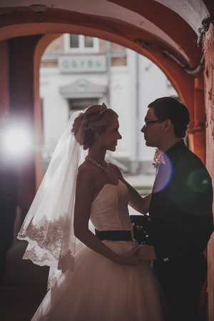 Closeup portrait of bride and groom kissing in ancient tunnel made of bricksの写真素材