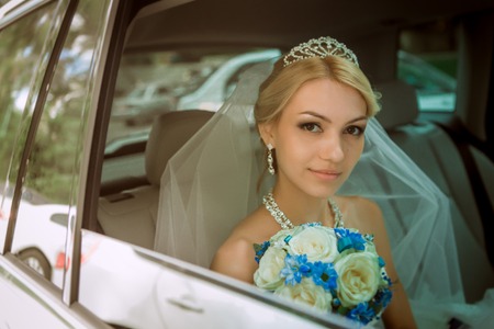 close-up portrait of a pretty shy bride in a car windowの写真素材