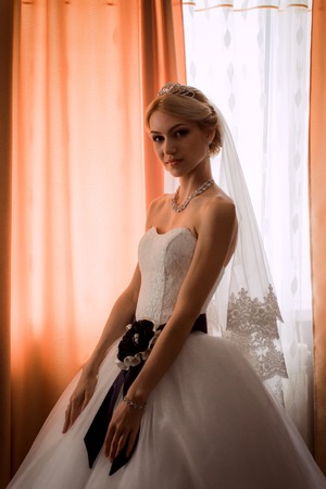 bride in a beautiful dress near the  windowの写真素材
