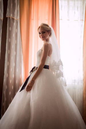 bride in a beautiful dress near the  windowの写真素材