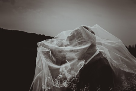 Kissing wedding couple in high grass