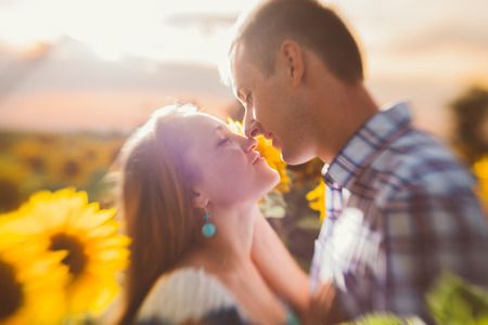 Beautiful couple having fun in  sunflowers fieldsの写真素材