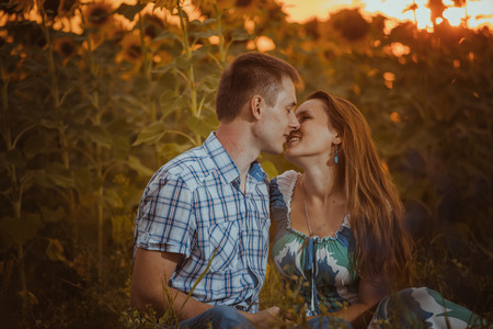 Beautiful couple having fun in  sunflowers fieldsの写真素材