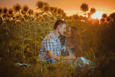 Beautiful couple having fun in  sunflowers fieldsの写真素材