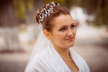 Beautiful bride in wedding dress and  bridal bouquet, happy newlywed woman with wedding flowers, woman with wedding makeup and hairstyle. gorgeous young bride outdoors. Bride waiting for groom. brideの写真素材
