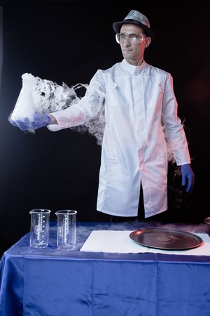 Smiling man  scientist with dry ice