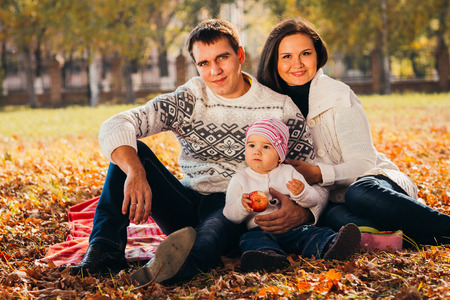 Happy mother, father and daughter in the  parkの写真素材