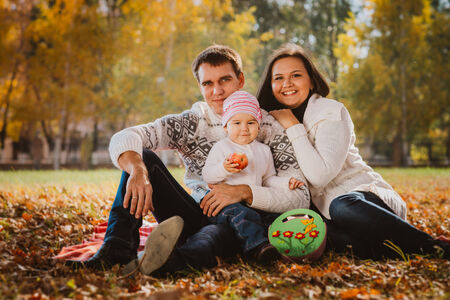 Happy mother, father and daughter in the  parkの写真素材