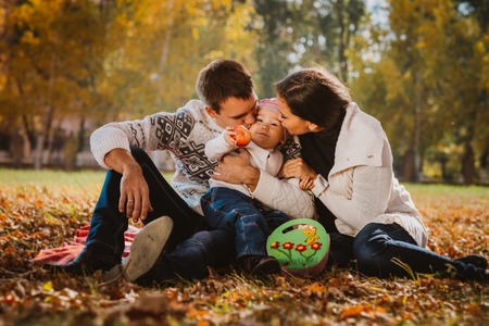 Happy mother, father and daughter in the  parkの写真素材