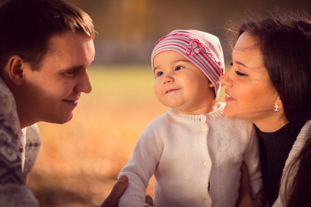 happy young family spending time  outdoor in the autumn parkの写真素材