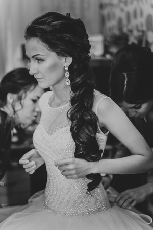 Beautiful young bride with  wedding makeup and hairstyle in bedroom, newlywed woman final preparation for wedding. Happy Bride waiting groom. Marriage Wedding day moment. Bride portrait soft focusの写真素材