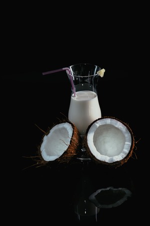 Pina Colada over black background, with coconut.